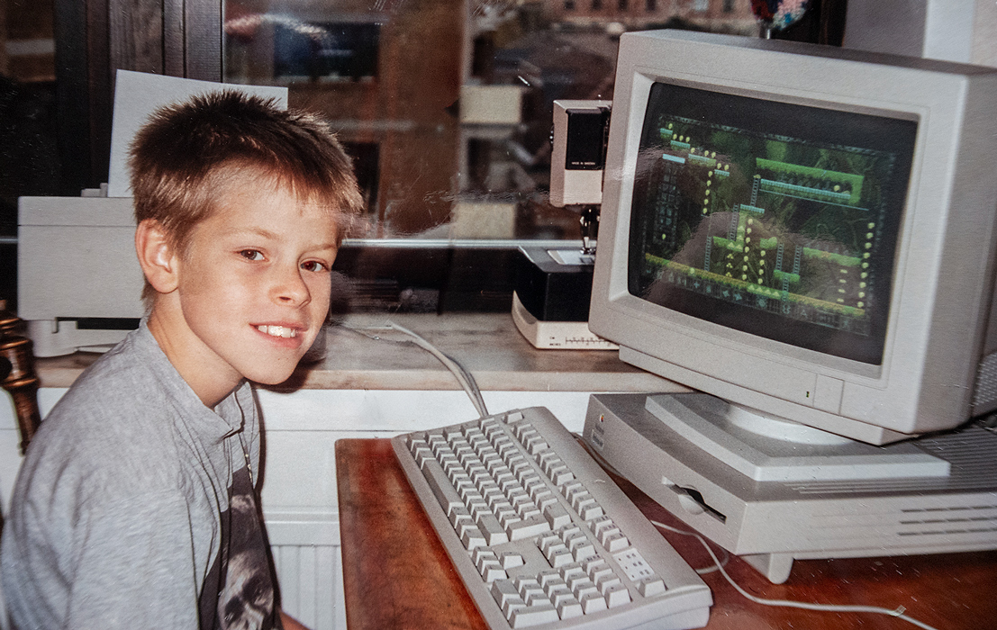 Alfred as a kid, smiling next to a 90s computer